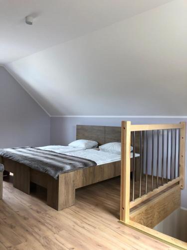 1 dormitorio con 1 cama con marco de madera en Ośrodek Wypoczynkowy OAZA, en Bukowice