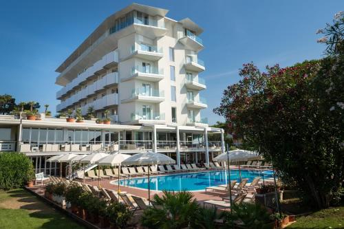 un hotel con piscina, sillas y sombrillas en Hotel Garden Sea Wellness & Spa 4 stelle superior, en Caorle