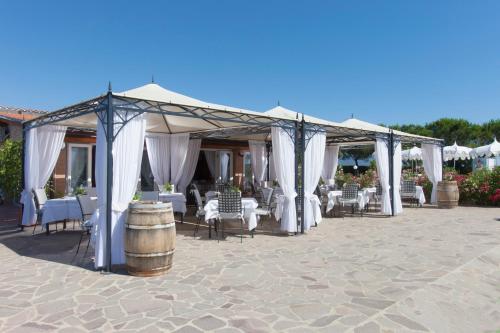 a group of tables and chairs under a tent at Fattoria Maremmana in Marina di Grosseto