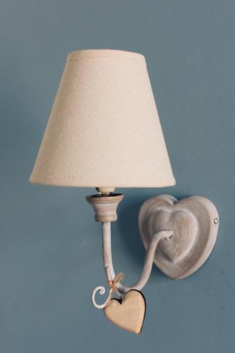 a lamp with a snail on the wall next to a heart at Alle Scalette B&B in Lauria