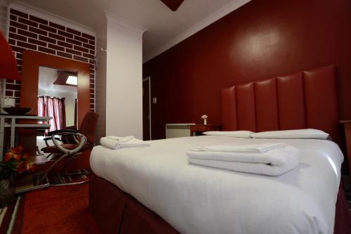 a hotel room with a bed with towels on it at Park Hotel in Ilford