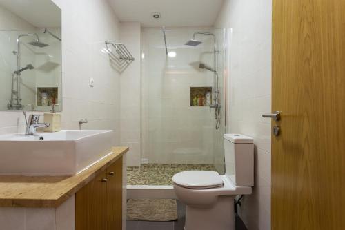 a bathroom with a toilet and a sink and a shower at Graca House in Lisbon