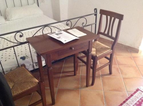 a table and two chairs and a bed at Le Copertelle Bed & Breakfast in Serra San Quirico
