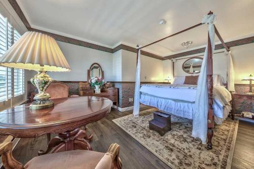 1 dormitorio con 1 cama y 1 mesa en Silver Maple Inn and The Cain House Country Suites en Bridgeport