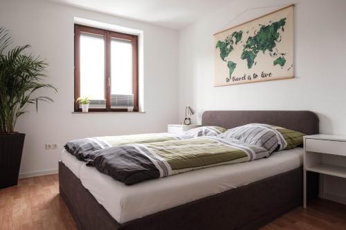 a bed in a bedroom with a world map on the wall at FeWo Alte Mainbrücke in Würzburg