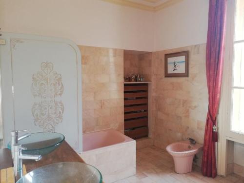 a bathroom with a pink tub and a sink at Château de la Bucaille - entier in Aincourt