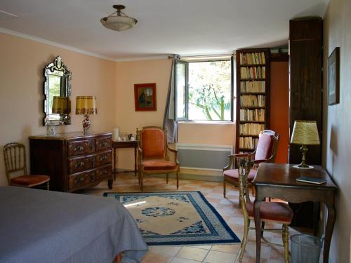 Schlafzimmer mit einem Bett, einem Schreibtisch und einem Fenster in der Unterkunft B&B du Pré-Boulay in Fleury-la-Forêt
