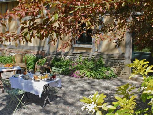 een tafel met eten erop in een tuin bij B&B du Pré-Boulay in Fleury-la-Forêt