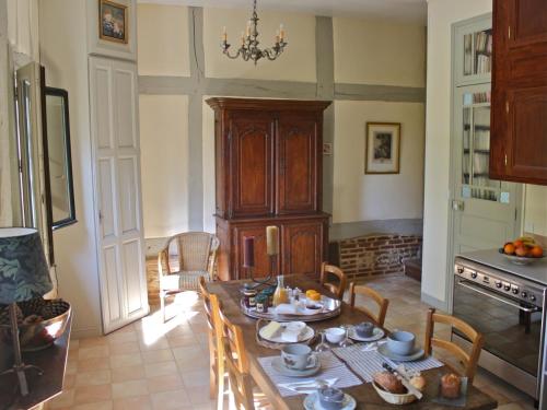 een eetkamer met een tafel en stoelen in een keuken bij B&B du Pré-Boulay in Fleury-la-Forêt