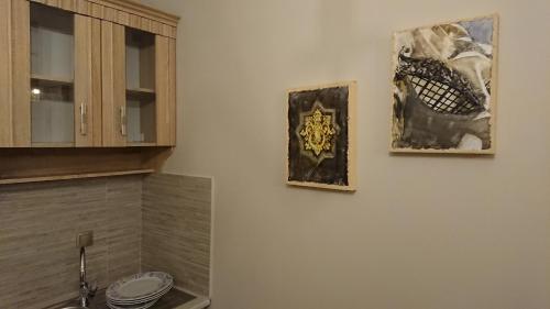 two pictures hanging on a wall in a kitchen at Stone house with seaview in Nea Potidaea