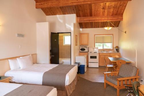 a hotel room with two beds and a kitchen at Rocky Mountain Ski Lodge in Canmore