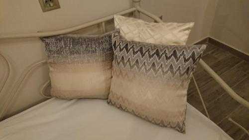 a bed with two pillows on it next to at Stone house with seaview in Nea Potidaea