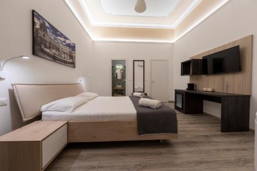 a bedroom with a large bed and a television at Sammartino suite in Palermo