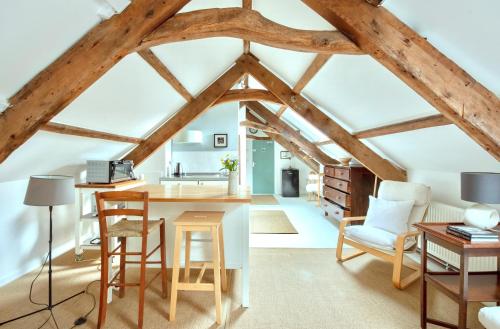 a kitchen and living room with wooden beams at The Attic Apartment, Quay Street Studios Cardigan in Cardigan