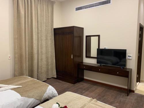 a hotel room with two beds and a flat screen tv at Miramar Talaat Harb Square in Cairo