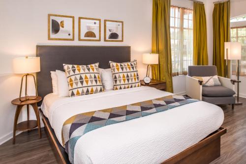 1 dormitorio con 1 cama grande y 1 silla en Wine Valley Inn, en Solvang
