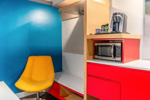
a kitchen with a red chair and a yellow wall at Century Park Hotel LA in Los Angeles
