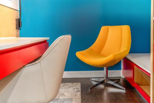 an orange chair in a kitchen with a blue wall at Century Park Hotel LA in Los Angeles