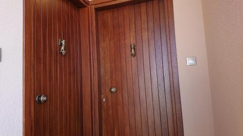 a wooden door with two handles in a room at Stone house with seaview in Nea Potidaea