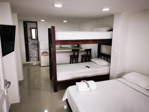 a room with two bunk beds with white sheets at Bull Shark in San Andrés