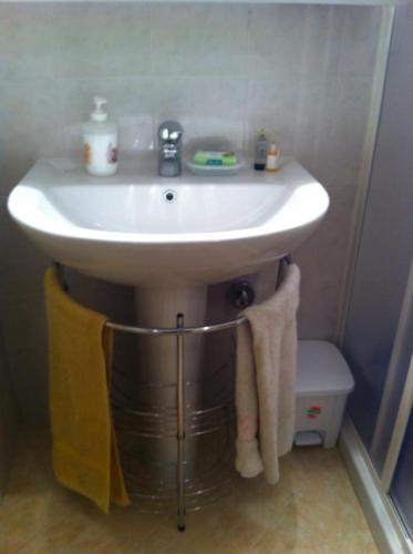 a white sink in a bathroom with a toilet at La Casa di Edo in Goito