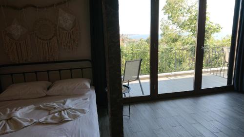 a bedroom with a bed and a view of a balcony at Stone house with seaview in Nea Potidaea