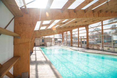 ein großer Pool mit einem großen Fenster in einem Gebäude in der Unterkunft Waikanae Beach TOP 10 Holiday Park in Gisborne