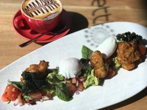 a white plate with food and a cup of coffee at Dandenong Central Apartments Official in Dandenong