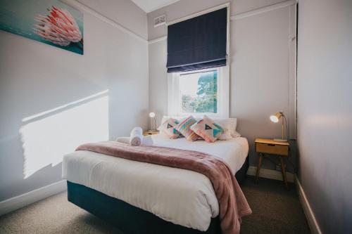 a small bedroom with a bed and a window at Duke of Wellington Hotel in New Lambton