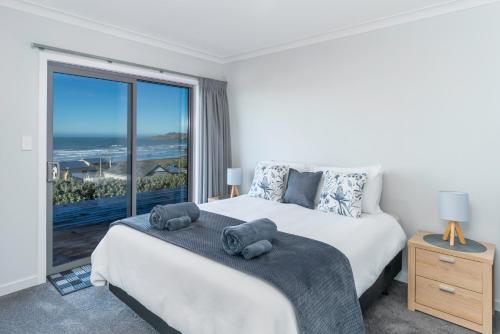 una camera con un letto e una grande finestra di Kaka Point Views Apartment 1 a Kaka Point