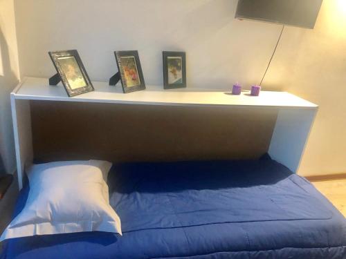 a bed with a shelf with pictures on it at Departamento Centro Vista al Obelisco para 5 personas in Buenos Aires