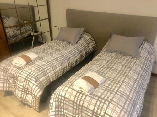 two beds sitting next to each other in a room at Departamento Centro Vista al Obelisco para 5 personas in Buenos Aires