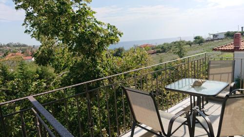 a table and chairs on a balcony with a view at Stone house with seaview in Nea Potidaea