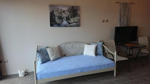 a bedroom with a bed with a blue blanket at Stone house with seaview in Nea Potidaea