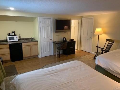 a hotel room with a bed and a kitchen at Four Winds Country Motel in Manchester