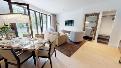 een eetkamer en een woonkamer met een tafel en stoelen bij White Pearl Apartment 0.01 in Timmendorfer Strand
