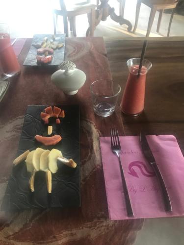 a table with two plates of food and a fork and knife at Eco dive resort Alycastre in Maumere