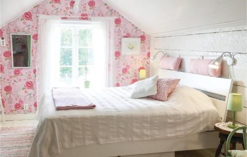 ein Schlafzimmer mit einem weißen Bett mit rosafarbener Blumentapete in der Unterkunft Lovely Home In Sollebrunn With Wifi in Sollebrunn