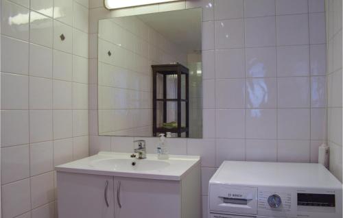 Baño blanco con lavabo y espejo en Leil, 705, en Kragerø