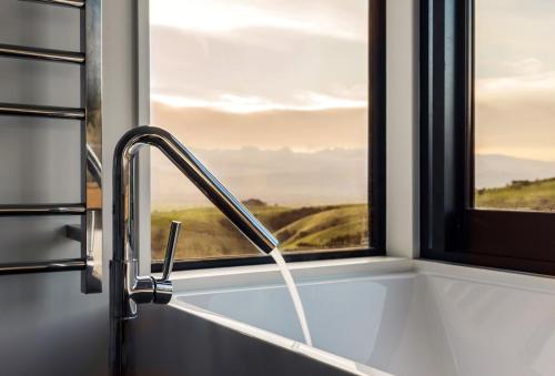 um lavatório de cozinha com uma torneira e uma janela em Whitimanuka Retreat em Martinborough