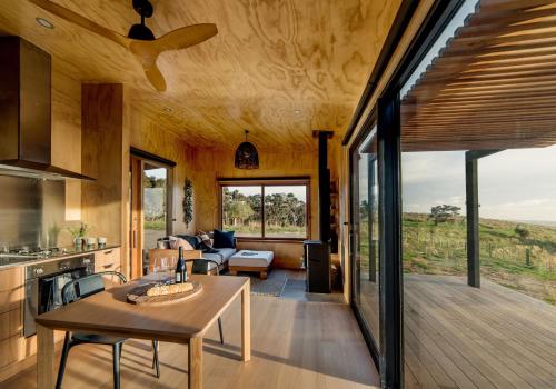 a kitchen and living room of a house with a table at Whitimanuka Retreat in Martinborough 