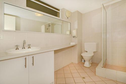 a bathroom with a sink and a toilet and a mirror at Mandurah Motel and Apartments in Mandurah