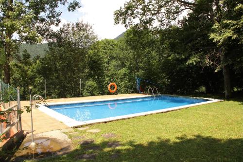 a large swimming pool in a yard with trees at Camping Abadesses in Sant Joan de les Abadesses