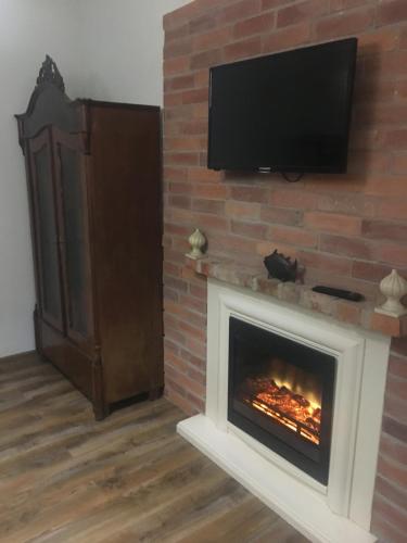a fireplace with a television on a brick wall at Welch in Zaniemyśl