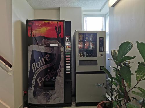 a drink vending machine with a bottle of coke at Auberge de la Gare in Gatineau