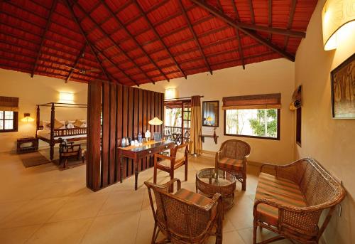 a living room with a table and chairs at Raindrops Resorts in Sultan Bathery