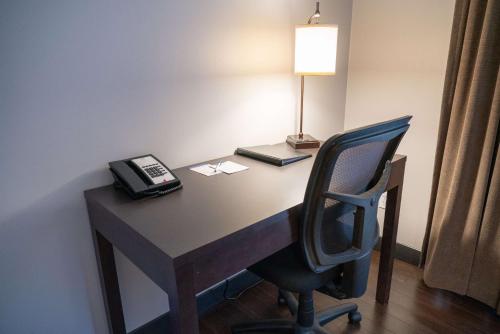 a desk with a phone and a chair in a room at Pocaterra Inn & Waterslide in Canmore