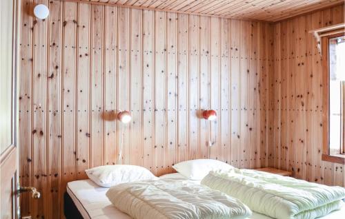 two beds in a room with wooden walls at Amazing Home In Sysslebäck With Kitchen in Sysslebäck