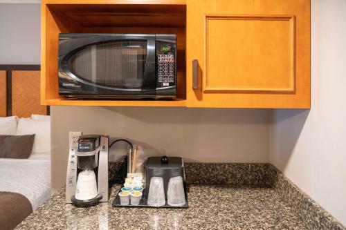 a kitchen counter with a microwave and a coffee maker at Pocaterra Inn & Waterslide in Canmore