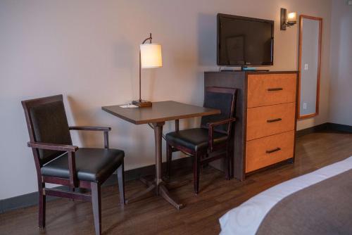 a hotel room with a table and chairs and a television at Pocaterra Inn & Waterslide in Canmore
